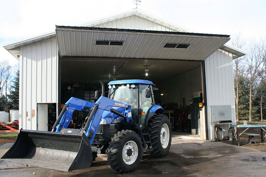 bifold door on white shed with a blue tractor