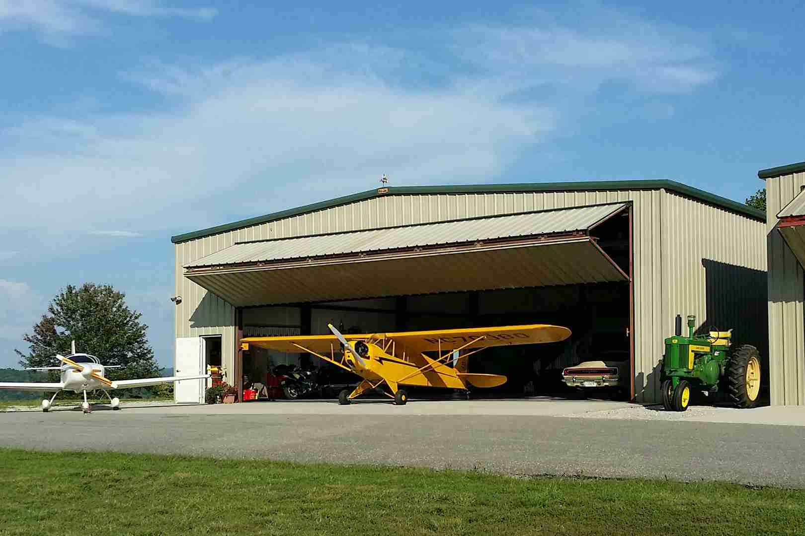 planes and tractor by hangar with bifold door