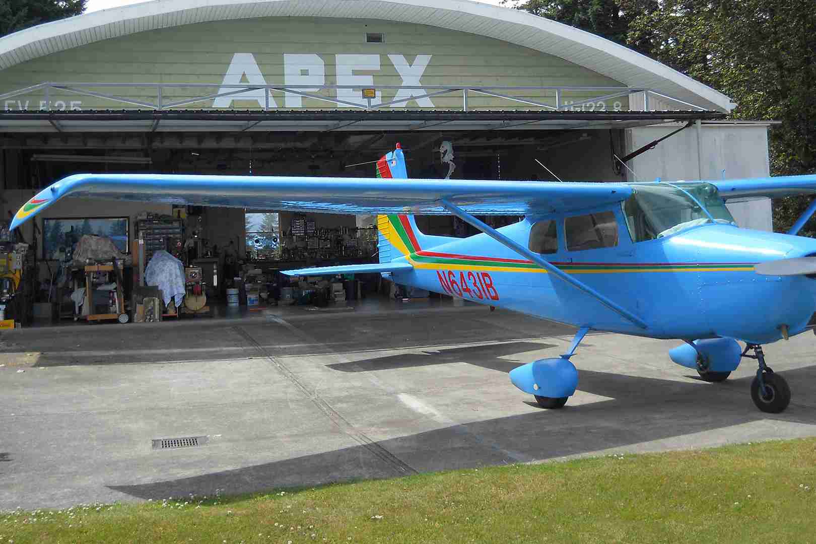 blue plane in front of hydraulic door hangar